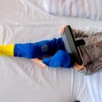 little boy with broken leg playing on tablet P5YFM4W